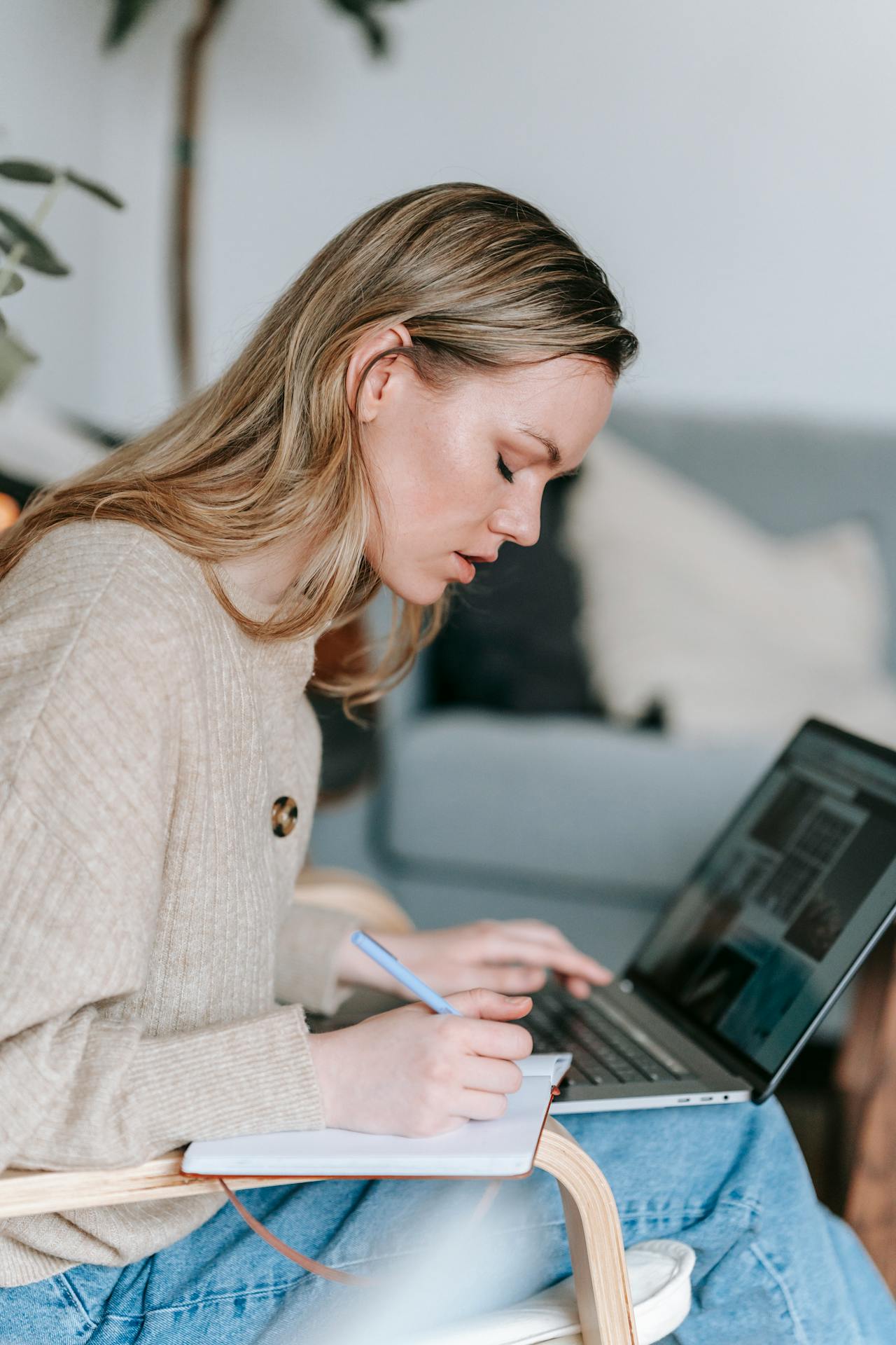 Student working with laptop and writing notes in planner