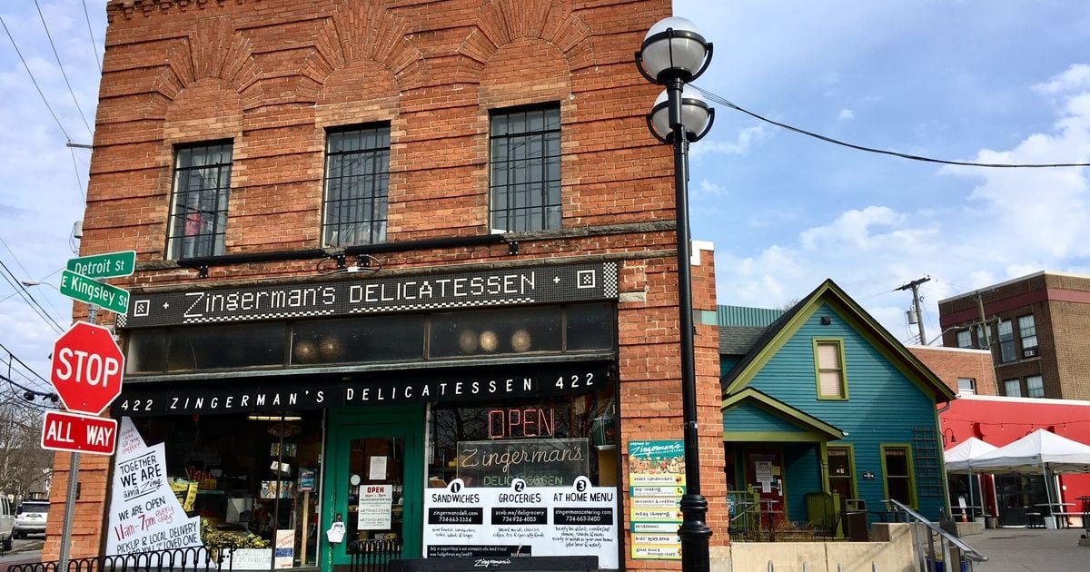 Local Brand Storytelling Frameworks That Actually Work image Exterior photo of Zingerman’s Delicatessen in Ann Arbor, a brick corner storefront with a ‘Zingerman’s Delicatessen’ sign, street signs (Detroit St and E Kingsley St), a stop sign, and an ‘OPEN’ window sign.